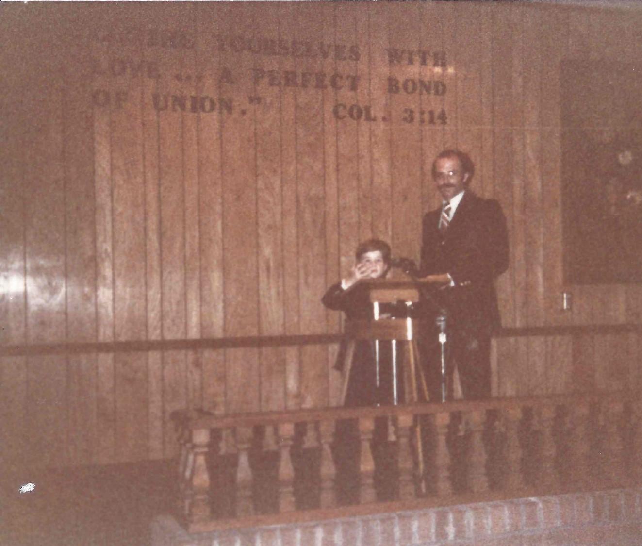 Young Spencer with his father at the Kingdom Hall podium